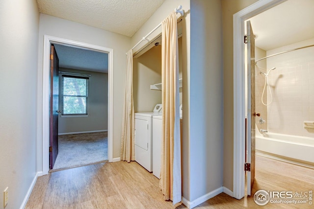 2924 Ross Dr Unit H20, Fort Collins, CO 80526 - hall with light wood-type flooring, washing machine and clothes dryer, baseboards, and a textured ceiling
