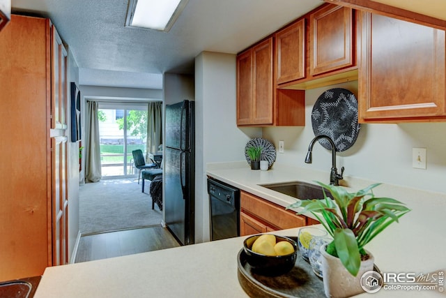 2924 Ross Dr Unit H20, Fort Collins, CO 80526 - kitchen featuring light countertops, a textured ceiling, black appliances, brown cabinets, and a sink