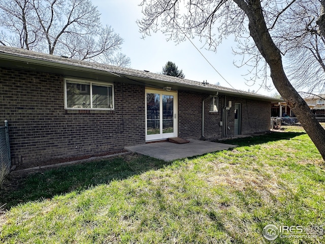 back of property featuring brick siding, a yard, and a patio area