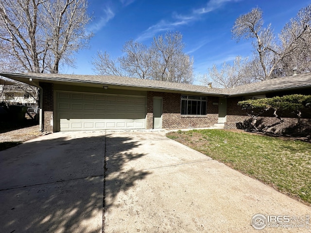 single story home featuring brick siding, a front yard, a garage, and concrete driveway