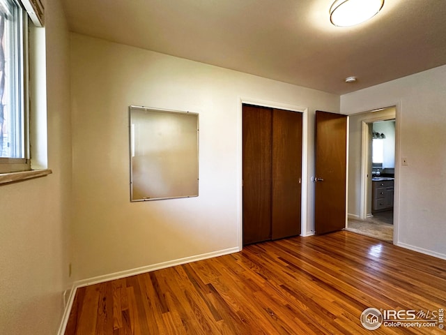 1401 Constitution Ave, Fort Collins, CO 80521 - unfurnished bedroom featuring a closet, baseboards, and wood finished floors