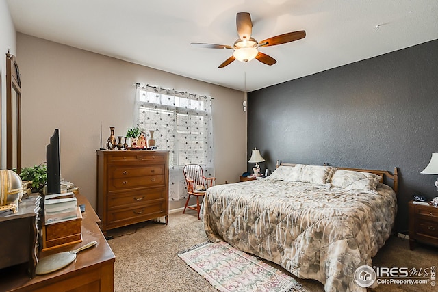 carpeted bedroom featuring a ceiling fan and an office area