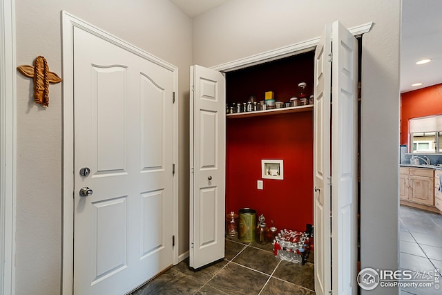laundry area with dark tile patterned flooring and hookup for a washing machine