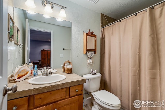 full bathroom featuring vanity, toilet, and a textured ceiling