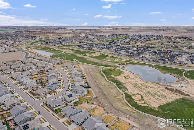 aerial view of property and surrounding area with a large body of water and nearby suburban area