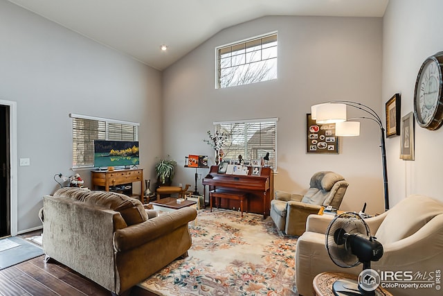 living room with wood finished floors, plenty of natural light, and high vaulted ceiling