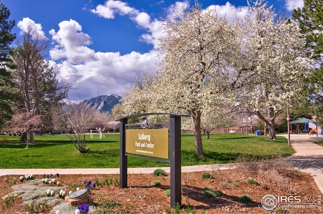 surrounding community with a mountain view and a lawn