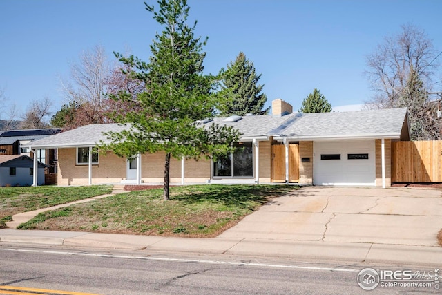 ranch-style house with brick siding, driveway, fence, and a garage