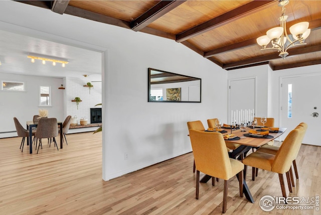 dining space with light wood-style flooring, wooden ceiling, a baseboard heating unit, a notable chandelier, and beam ceiling
