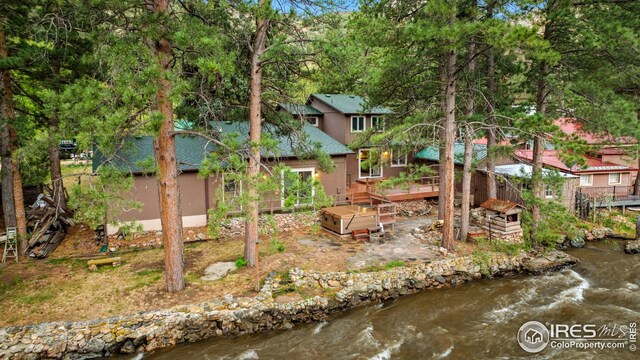 198 Poudre River Rd, Bellvue, CO 80512 - rear view of property with a deck, stucco siding, and roof with shingles