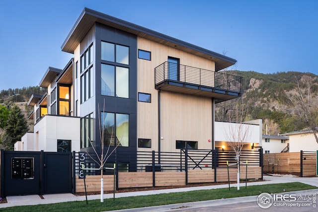 view of front of house featuring fence and a balcony