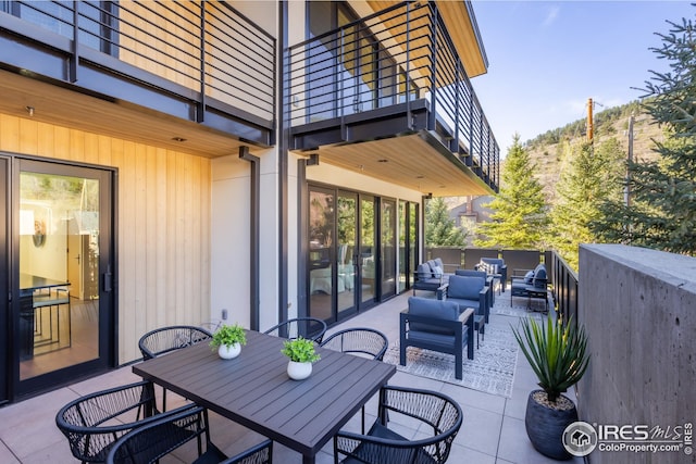 view of patio / terrace featuring an outdoor living space, outdoor dining space, and a balcony