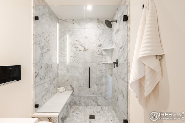 bathroom with a marble finish shower