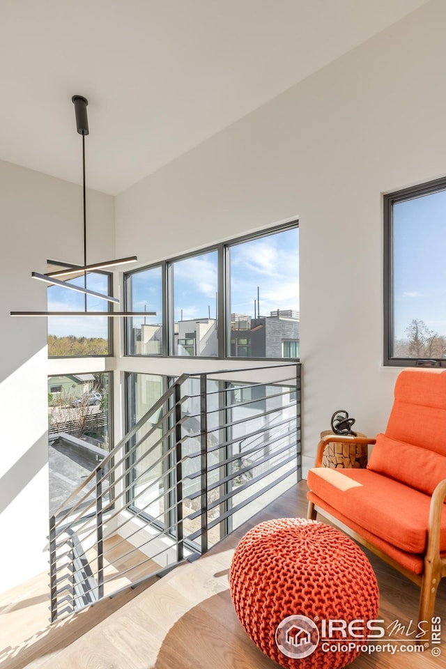 interior space featuring an upstairs landing, a healthy amount of sunlight, and wood finished floors