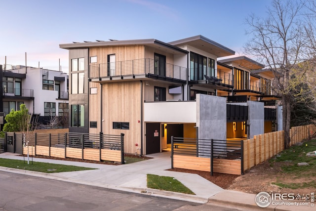 view of front of property with fence and a balcony