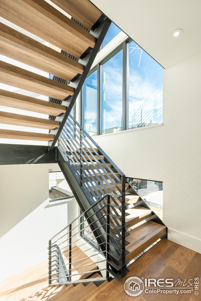 stairway with recessed lighting and wood finished floors
