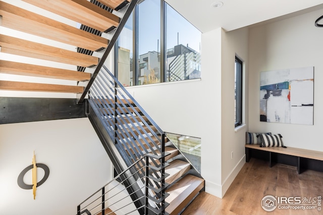 stairway with wood finished floors and baseboards