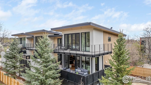 back of property with a balcony and an outdoor hangout area