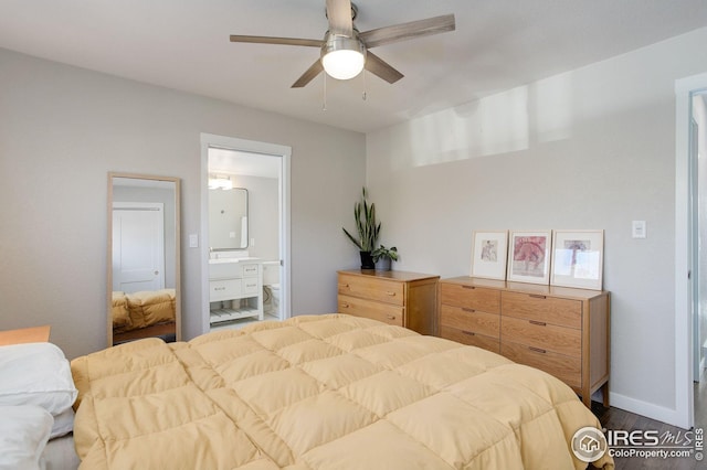 bedroom with baseboards, a ceiling fan, dark wood-style floors, and ensuite bath