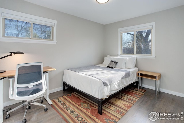 bedroom with baseboards and wood finished floors