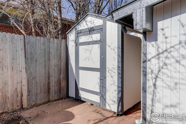 view of shed featuring fence