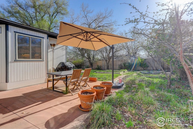 view of yard featuring a patio, outdoor dining area, and fence