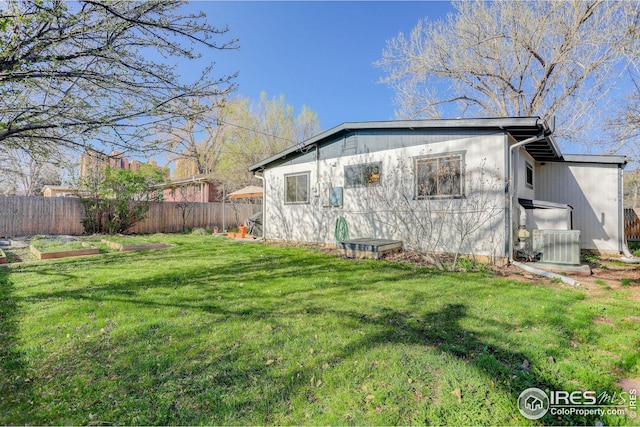 view of side of home featuring fence, a lawn, and cooling unit