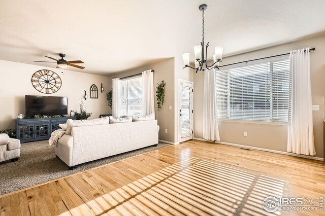 273 Mt Harvard Ave, Severance, CO 80550 - living area with baseboards, visible vents, wood finished floors, and ceiling fan with notable chandelier