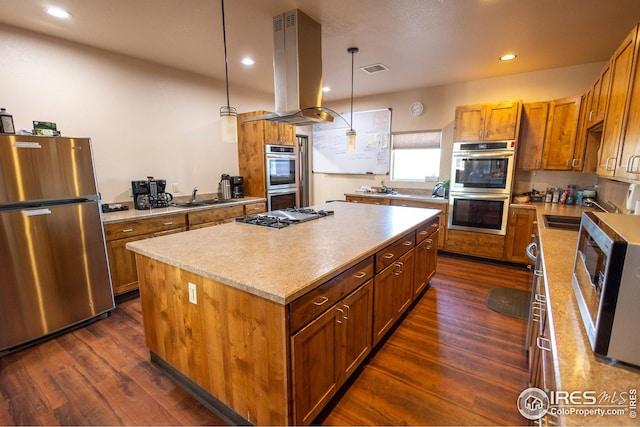 kitchen featuring a sink, appliances with stainless steel finishes, brown cabinets, island range hood, and a kitchen island