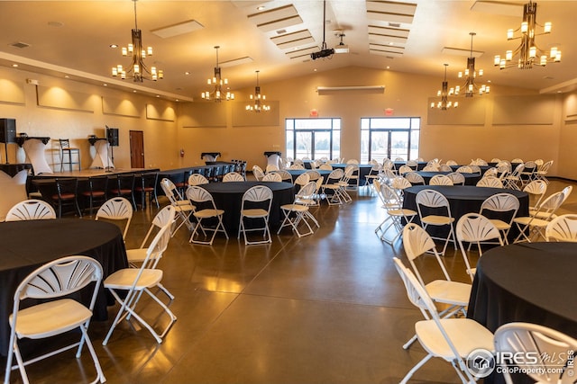 dining room with concrete floors, high vaulted ceiling, a notable chandelier, and visible vents