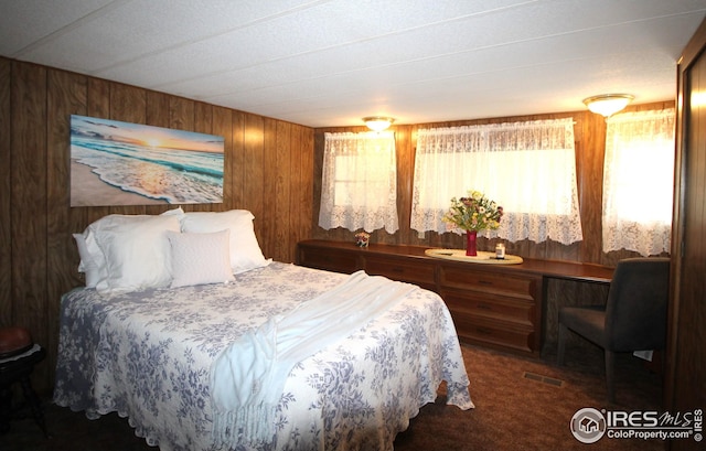 bedroom featuring wood walls, visible vents, and carpet floors