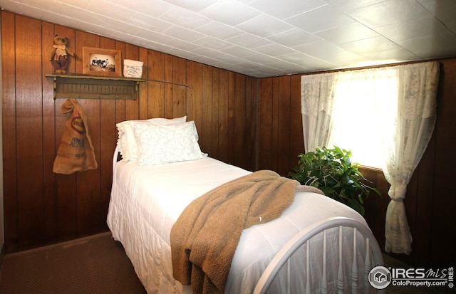 bedroom featuring wood walls