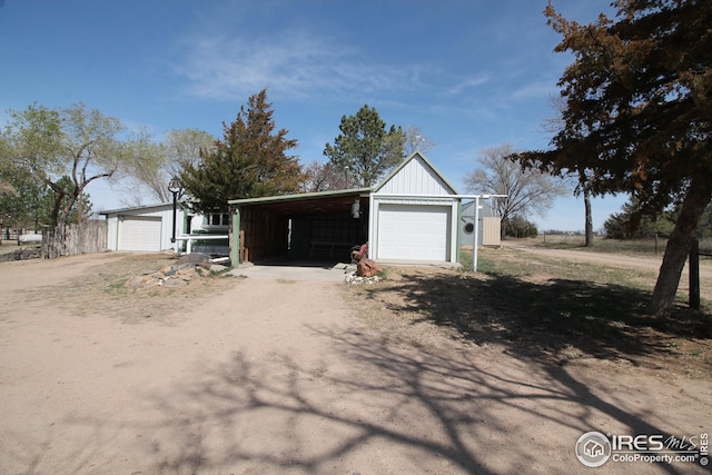 garage with a garage and dirt driveway