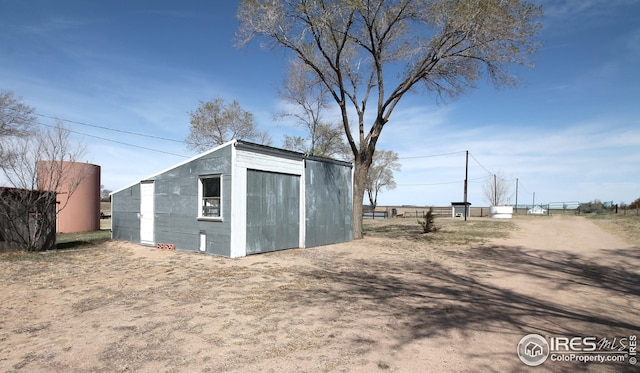 view of outbuilding with fence and an outdoor structure