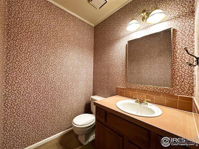 bathroom featuring wallpapered walls, lofted ceiling, toilet, vanity, and ornamental molding