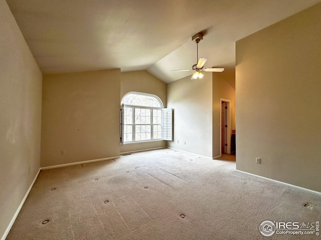 empty room with vaulted ceiling, baseboards, carpet, and ceiling fan