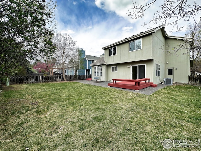 back of property with a wooden deck, a fenced backyard, a yard, and cooling unit
