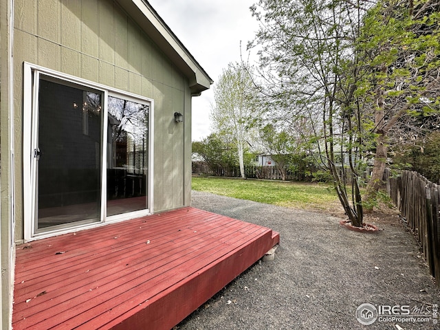 wooden terrace with a fenced backyard and a yard