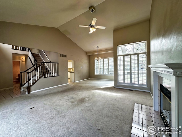 unfurnished living room featuring carpet, visible vents, and ceiling fan with notable chandelier