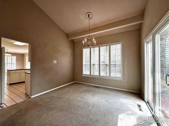 spare room featuring a notable chandelier, visible vents, a wealth of natural light, and light carpet