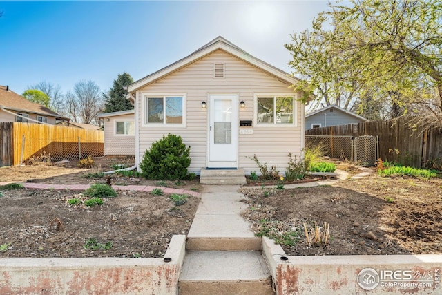 bungalow featuring entry steps and a fenced backyard