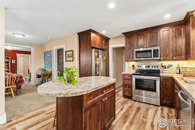 kitchen featuring backsplash, recessed lighting, stainless steel appliances, and light wood-style flooring