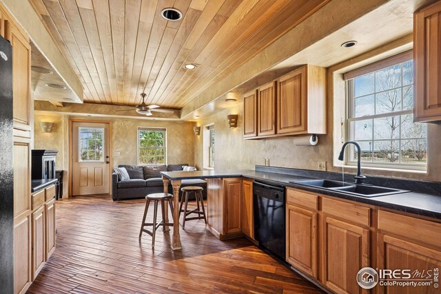 kitchen with black dishwasher, a sink, open floor plan, dark wood finished floors, and wood ceiling