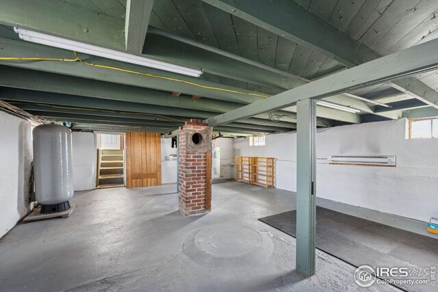 below grade area with electric water heater and stairway
