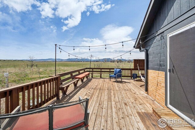 wooden deck with a mountain view and a rural view