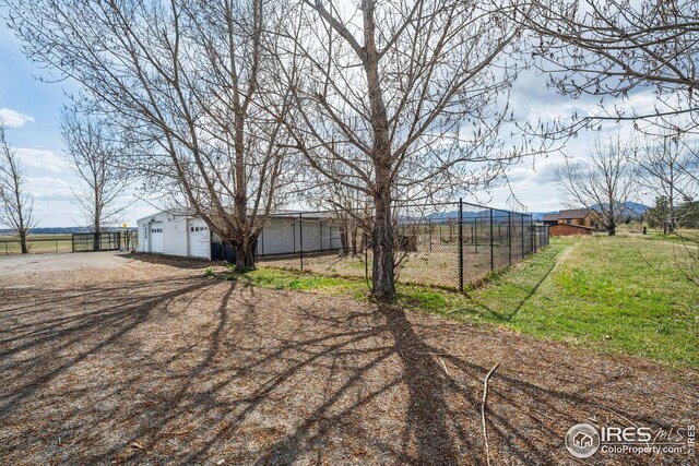 view of yard featuring a garage and fence