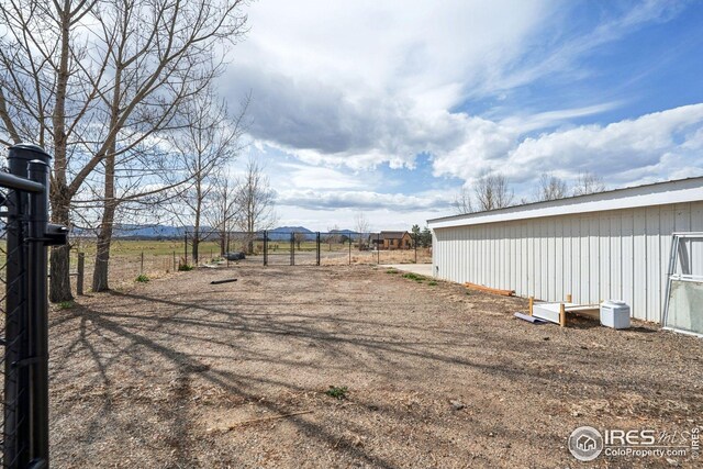 view of yard with fence and an outbuilding