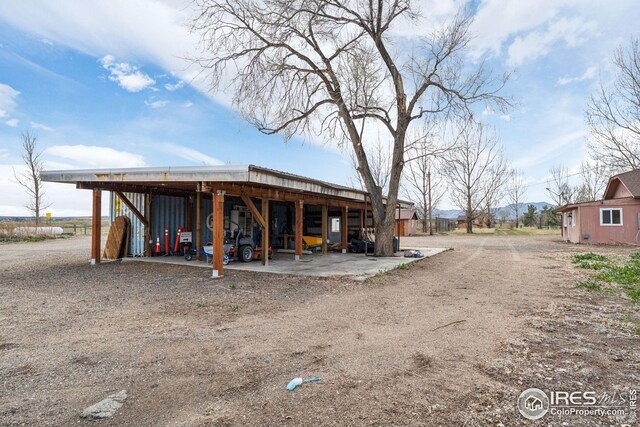 exterior space with a carport, an outbuilding, and dirt driveway