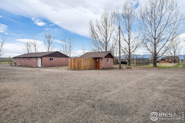view of side of property featuring fence and an outbuilding