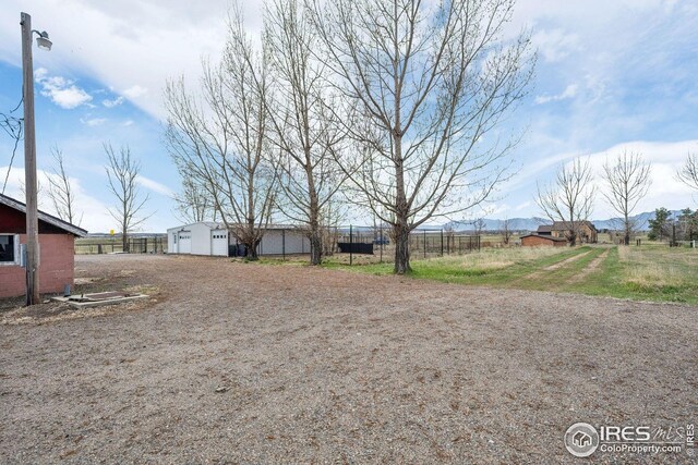 view of yard featuring an outbuilding and fence